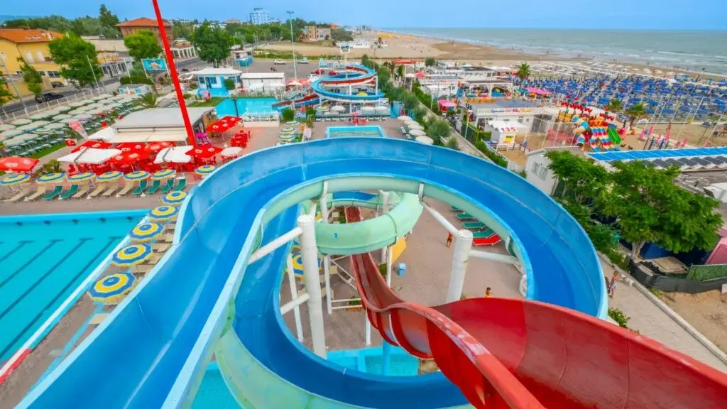 Vista dall'alto di Beach Village a Riccione con gli scivoli colorati, la piscina e la spiaggia sullo sfondo