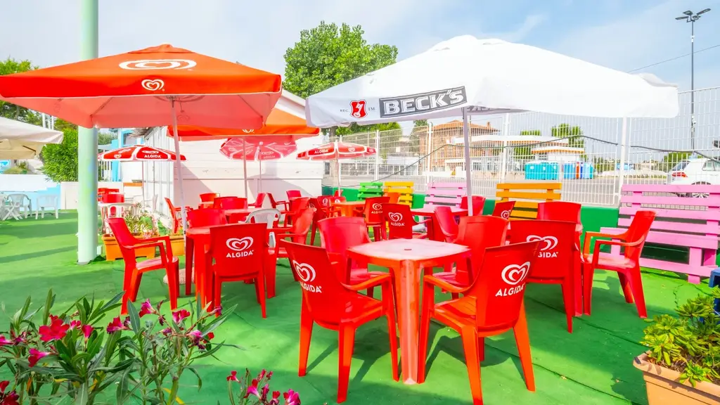 L'area bar di Beach Village con tavolini colorati e ombrelloni