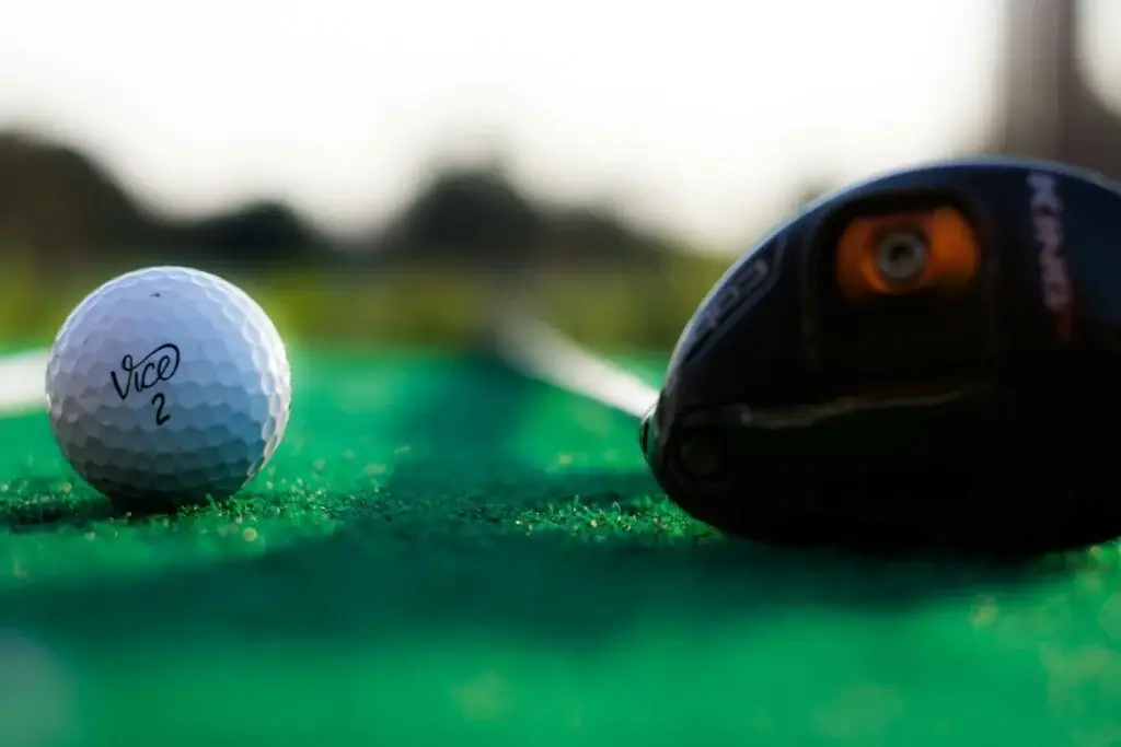 Gros plan sur une balle de golf et un club sur le green d'Indiana Golf à Riccione