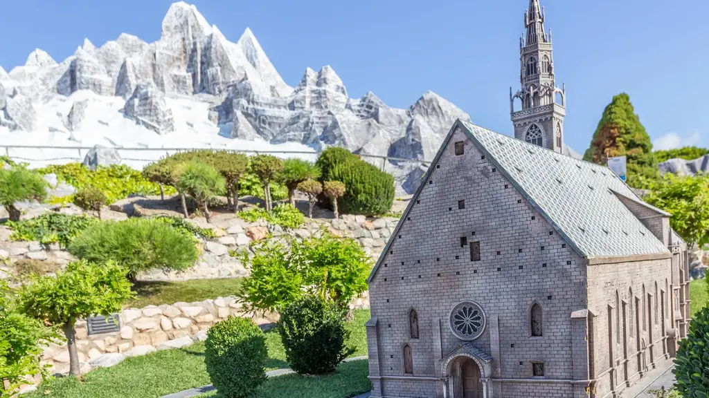 Une église alpine miniature avec les Dolomites enneigées en arrière-plan à Italia in Miniatura