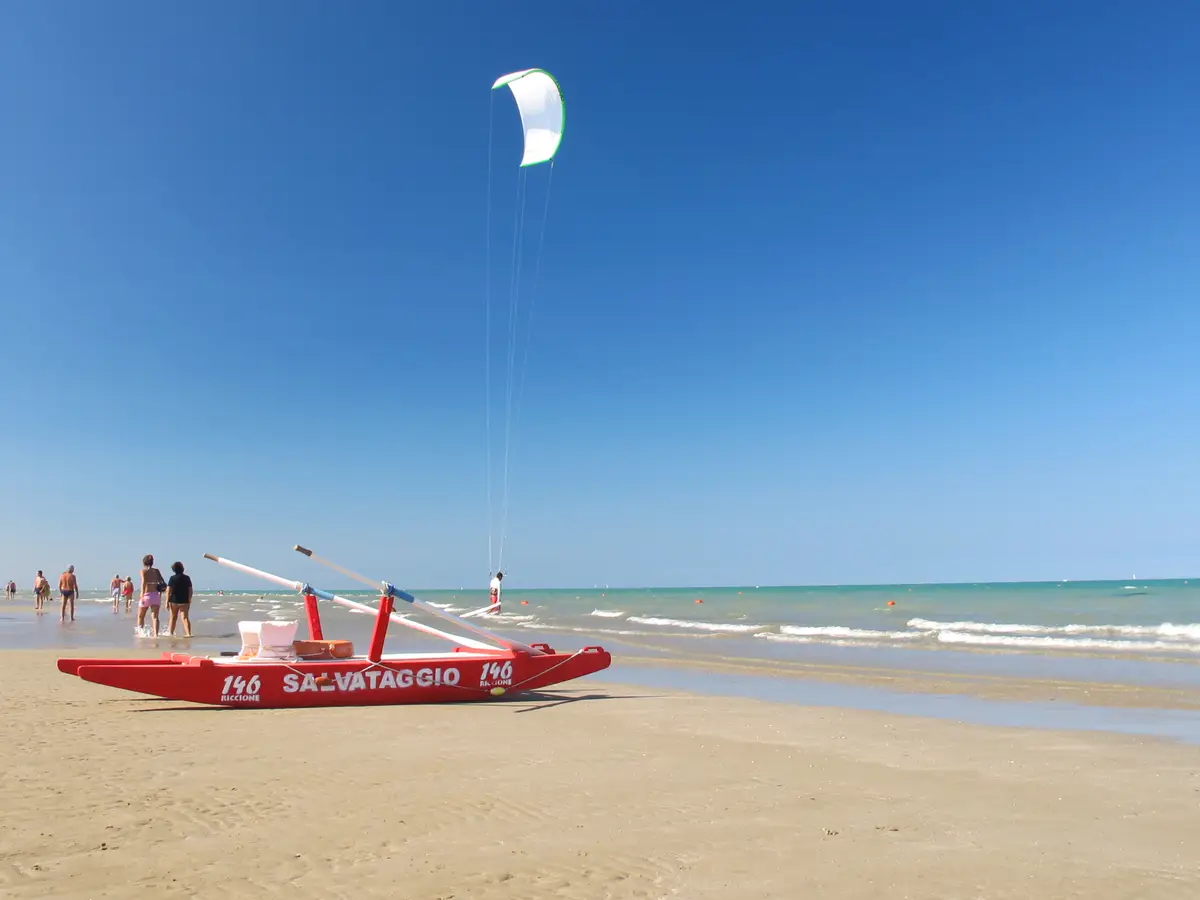 Plage libre de Riccione avec des baigneurs et des parasols colorés sur le sable